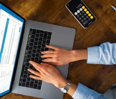 Person typing on laptop with calculator app