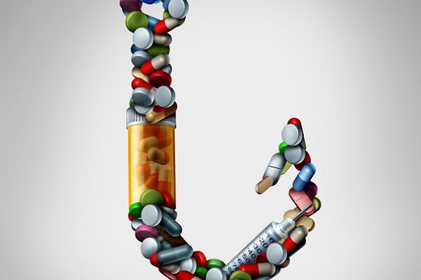 Hooked on medicine and addiction to meds as opiods risk as a hook made of pills and addictive medication as a medical health symbol for the dangers of being trapped by prescription drugs as a 3D illustration.