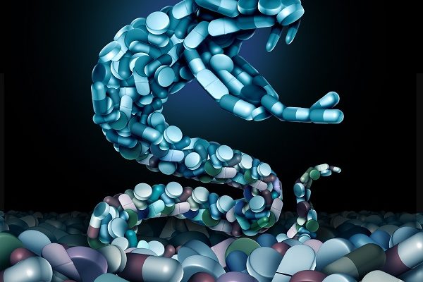 Opioids and opioid health risk and medical crisis with a prescription painkiller addiction epidemic concept as a group pills shaped as a snake with 3D illustration elements.