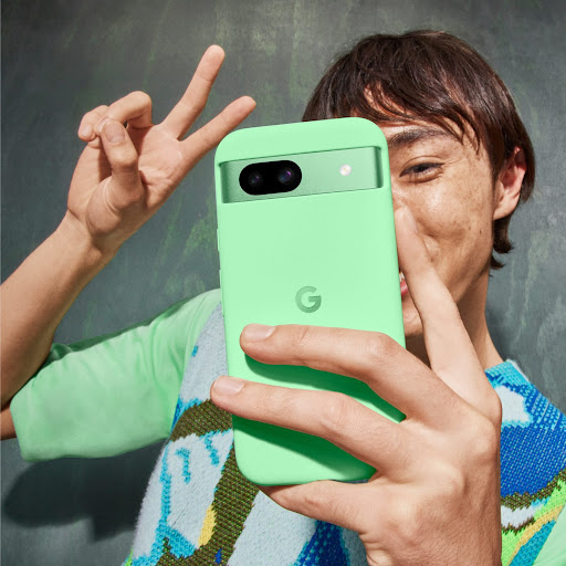 A person poses for a selfie with their Pixel 8a in Aloe color.