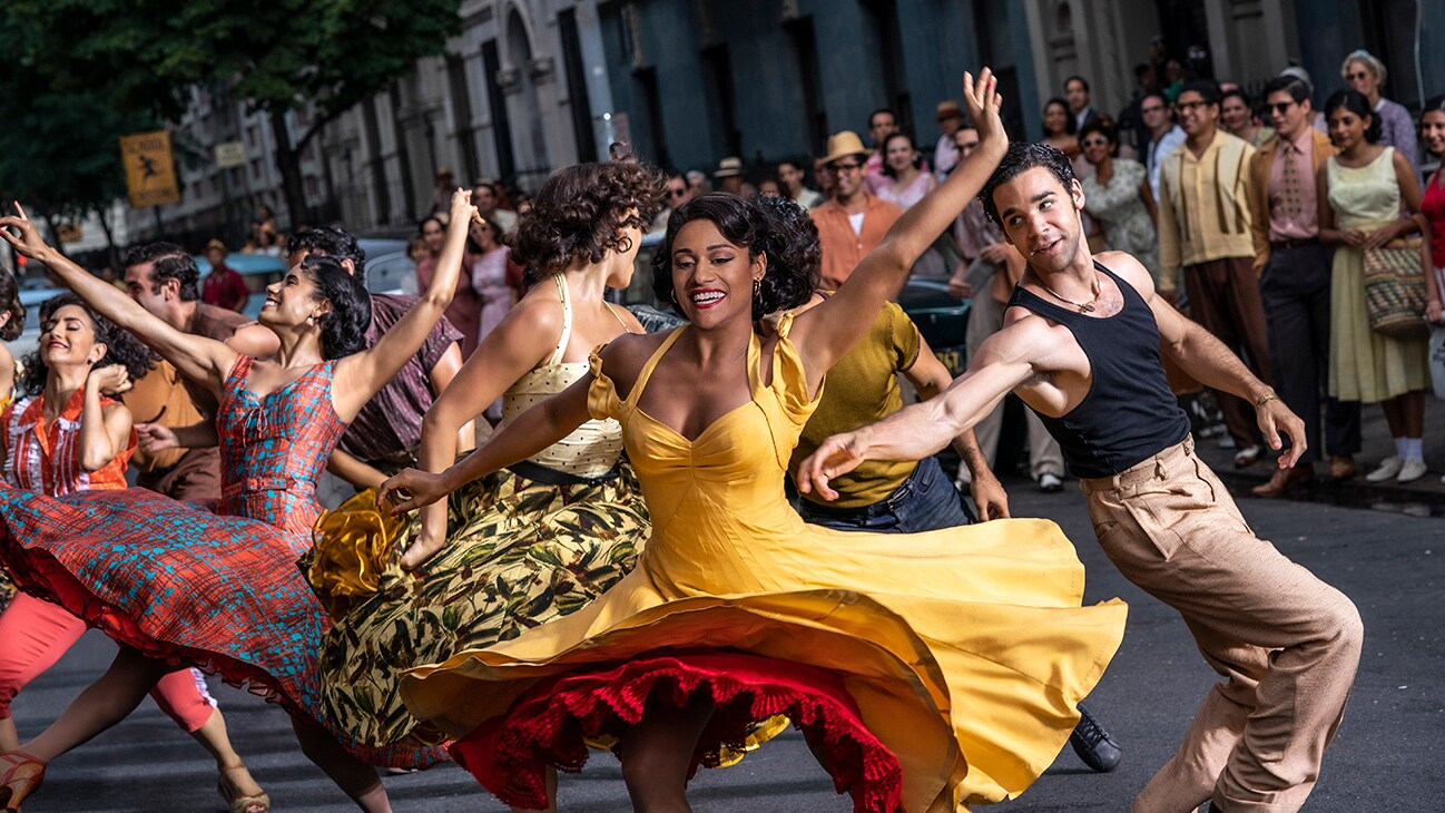 Actor Ariana DeBose dancing in the street with others from the 20th Century Studios movie "West Side Story".