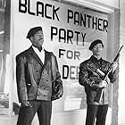 Founding members Bobby Seale (Courtney B. Vance) and Huey Newton (Marcus Chong) keep watch in front of Black Panther headquarters.
