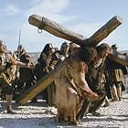  Simon of Cyrene (Jarreth Merz) helps Jesus (Jim Caviezel) carry his Cross.