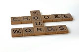 Scrabble tiles laid out to form the sentence: Choose your words.