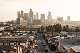 Picture of LA skyline in background and a neighborhood in the foregroundd