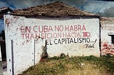 A wall with “Down with Capitalism” written in graffiti.