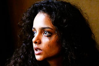 Young woman with dark curly hair crying