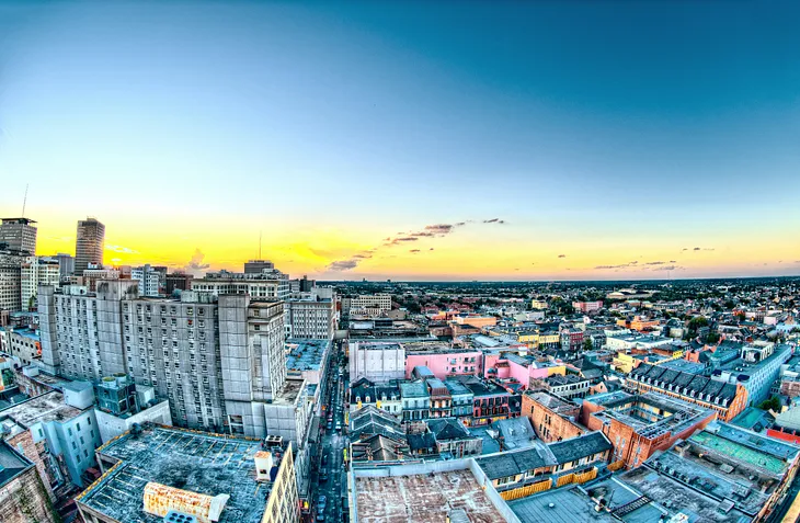 Sky view of a city, showing tall buildings as well as smaller residential buildings.