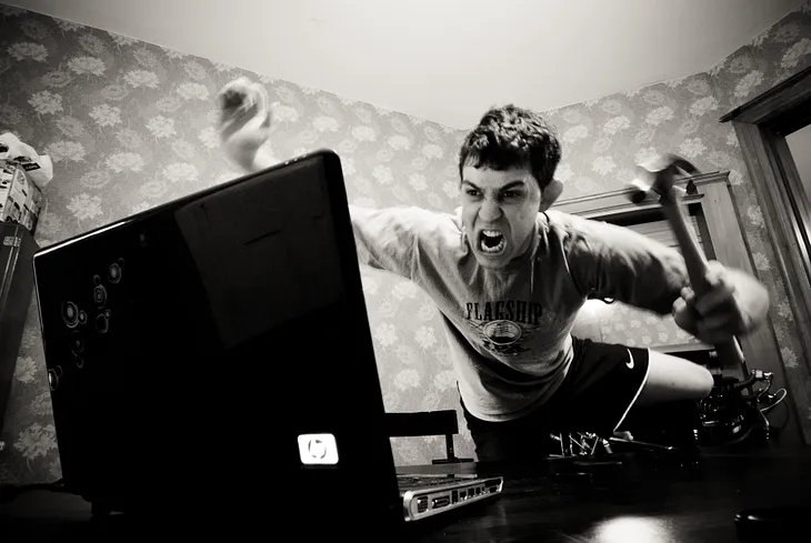 a man leaping toward a computer, attacking it with a swinging hand
