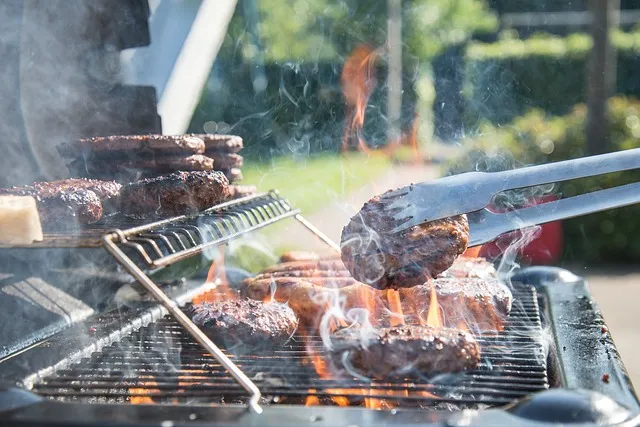 Meat sizzling on a barbecue grill as the smoke is rising up