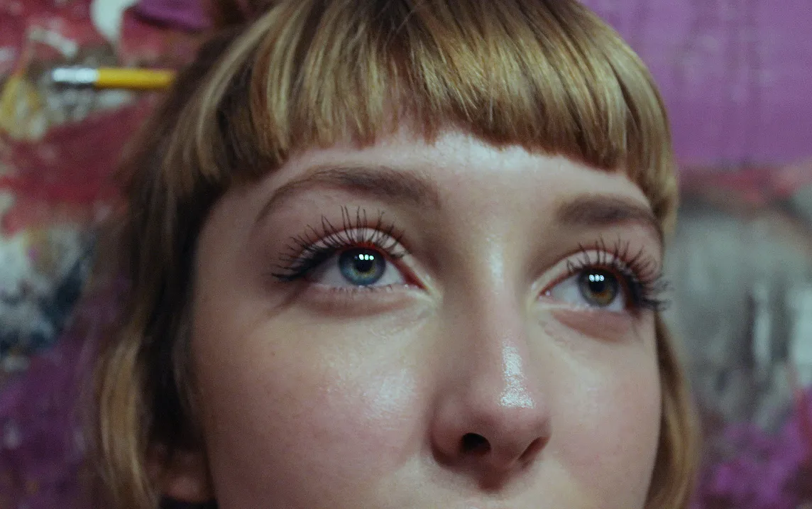 A woman with a fringe looks off into the distance