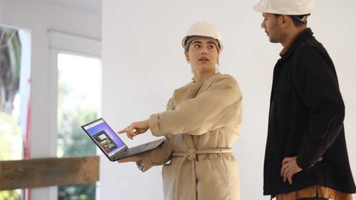 Facilities managers wearing hardhats using a mobile app featuring indoor location services.