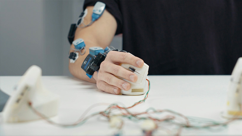 Bras droit équipé de capteurs de muscles, de posture et de pression testant un prototype de souris