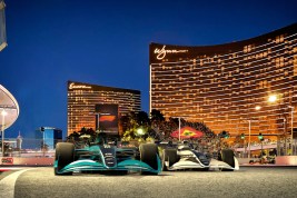 Two Formula 1 race cars with the Wynn Las Vegas in the background.