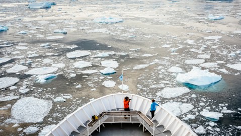 Passengers on the bow of a ship in Cierva Cove, Antarctica
