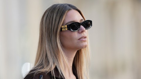 A woman wears Miu Miu sunglasses.