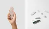 Two photos side-by-side: The first shows a hand holding up a coral-colored Chromecast remote against a blank light gray wall. The second photo shows a white Chromecast remote that’s disassembled completely, showing the wires and circuitry inside the remote.