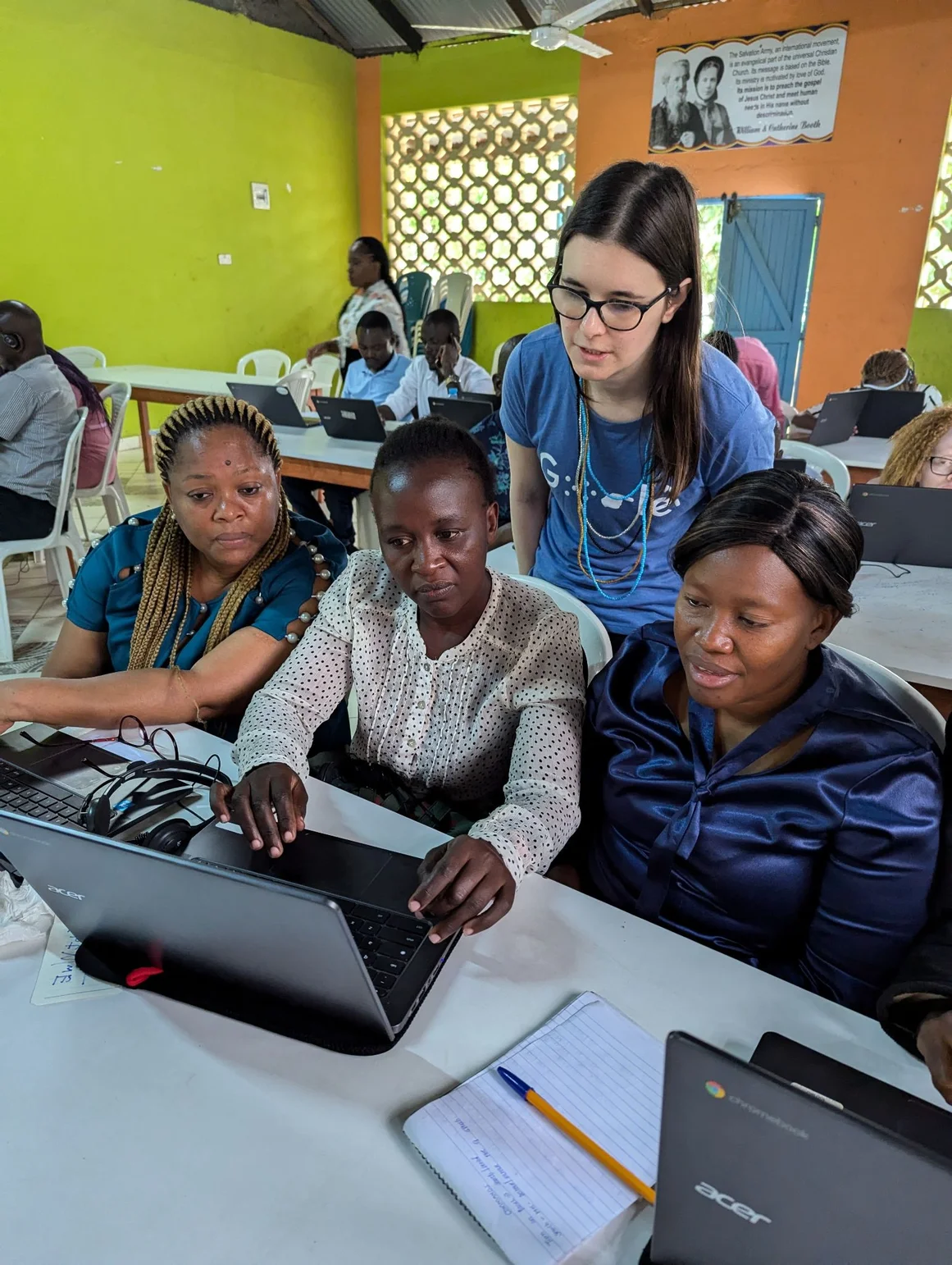 A fellow Googler stands over three teachers and helps teach Chromebook Accessibility at the Likoni School for the Visually Impaired, in Mombasa, Kenya.