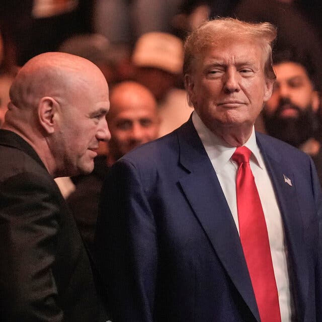 Donald Trump, right, half-smiles at Dana White, left, amid a small group of men.